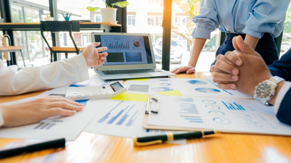 People talking around a conference table with papers.