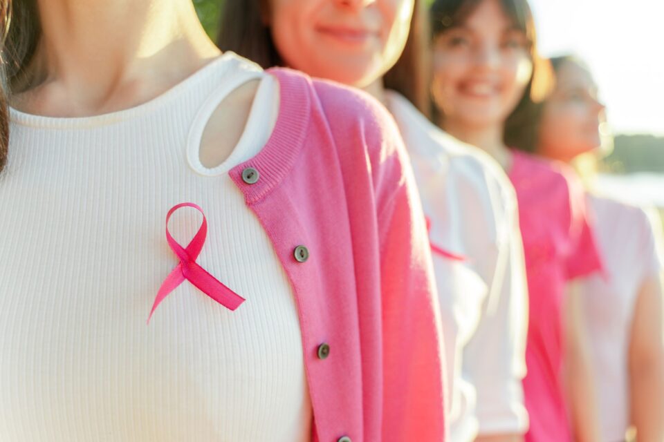 People in pink cardigans with a pink ribbon