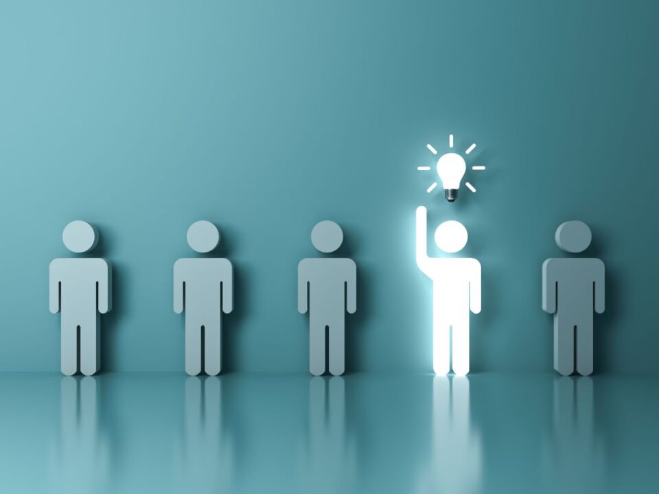 A lineup of stick figures with one glowing with a lightbulb above their head.